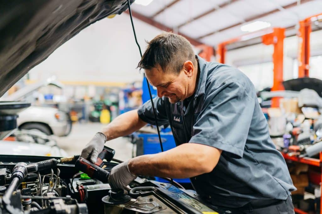 Technician working on vehicle engine